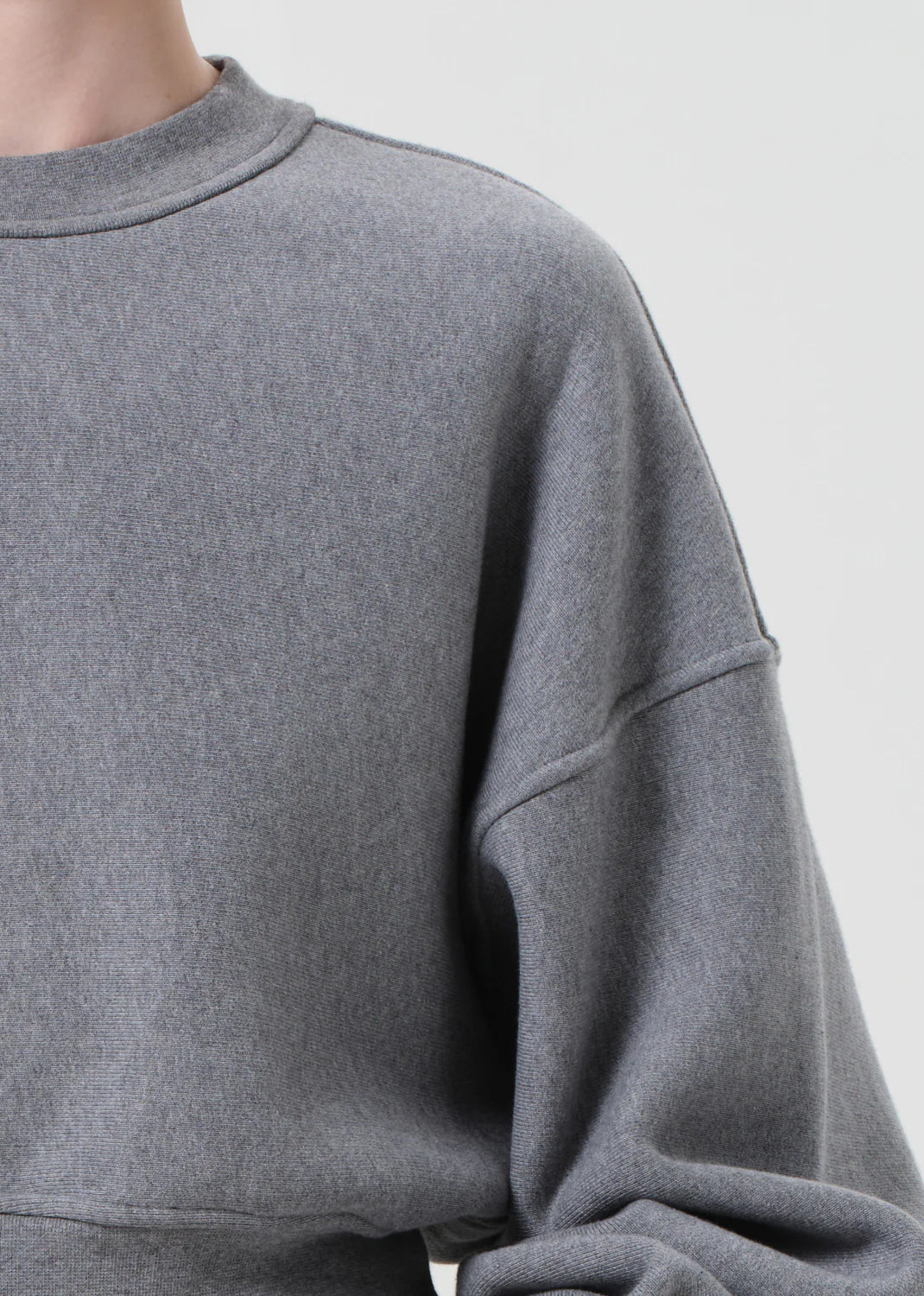 Detailed shot of the Kit Sweatshirt in Heather Grey, emphasizing its soft drape and relaxed fit.