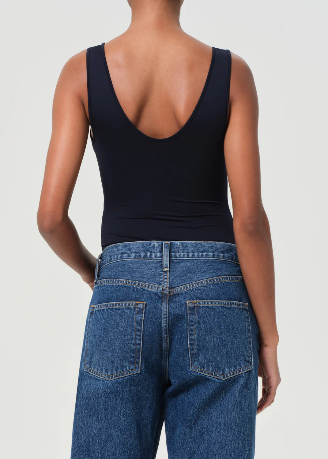 Agolde Tora Bodysuit in Mirage on a hanger, showcasing its lightweight design and classic style.