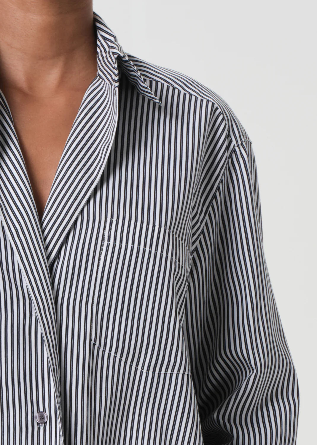 Side view of the Agolde Aris Shirt in Solene Stripe on a model, demonstrating effortless style over denim.