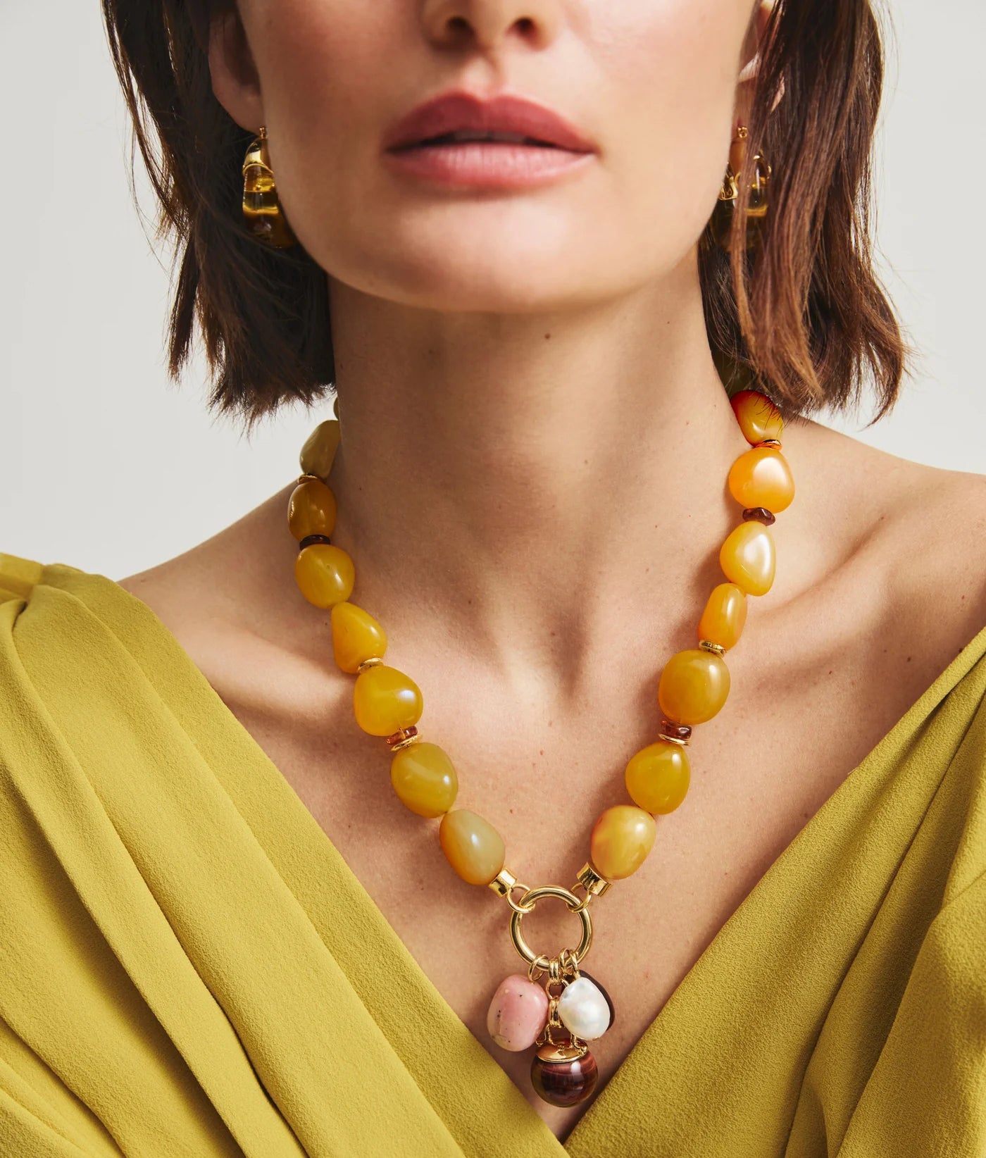 Close-up of Cordoba Charm Necklace in Multi highlighting vibrant yellow chalcedony beads and handcrafted charms inspired by Andalusia, Spain.