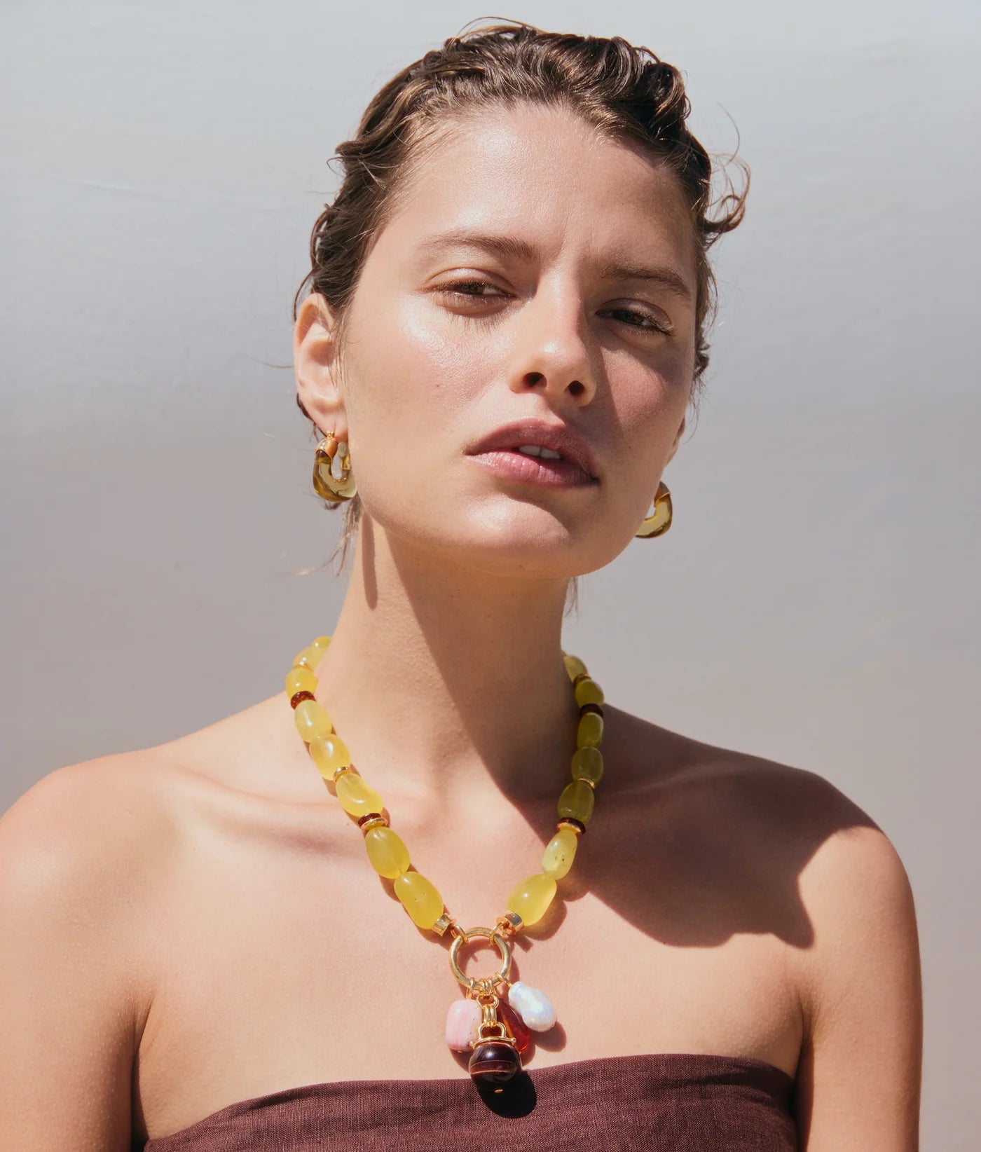 Stylish display of Cordoba Charm Necklace in Multi featuring gold-plated brass and colorful natural stones, perfect for statement fashion.