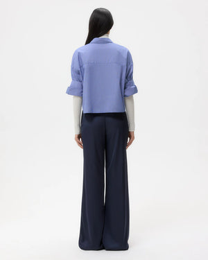 Model wearing TWP's Next Ex in White/Navy, highlighting the boxy silhouette and double roll button cuffs.