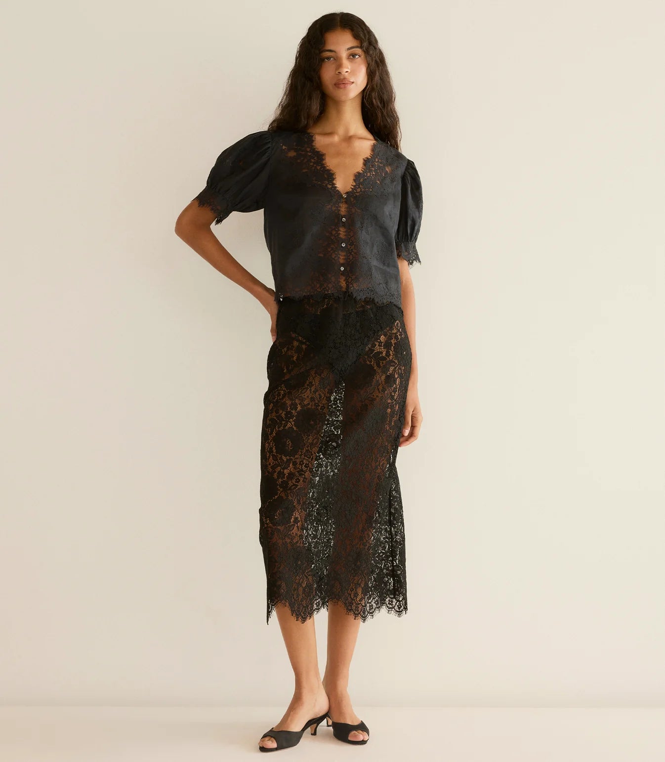 Close-up of the intricate embroidered floral lace trim on the Dôen Idella Top in Black.