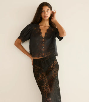 Model wearing the Dôen Idella Top in Black with a beautiful breeze capturing its lightweight fabric.