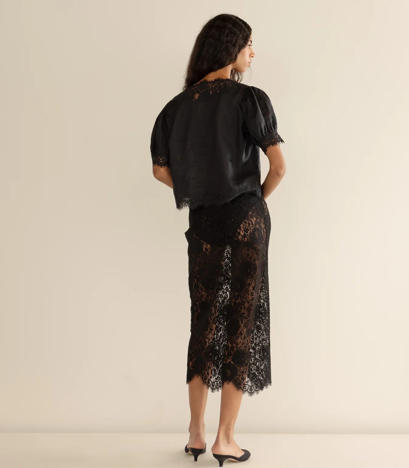 The Dôen Idella Top in Black showcasing lace insets on the sleeves and bodice.