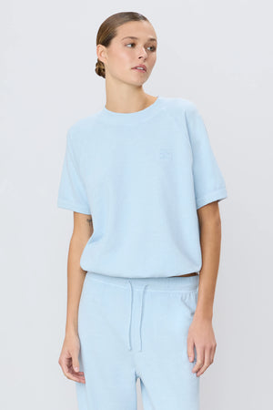 Close-up of the Short Sleeve Raglan Sweatshirt in Dusty Blue, showcasing the soft 100% cotton fabric of this essential short sleeve sweatshirt.