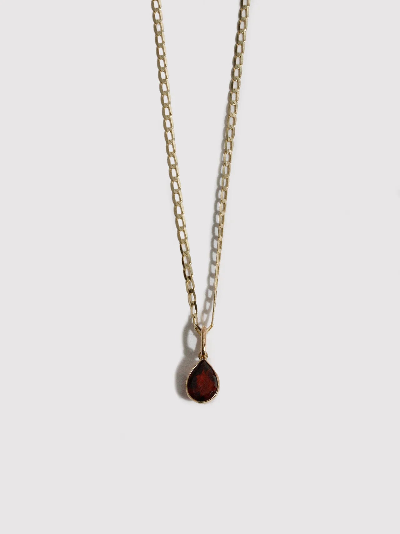 Scarlet Teardrop Charm in Garnet styled with a delicate chain, emphasizing its beauty and versatility as a jewelry piece.