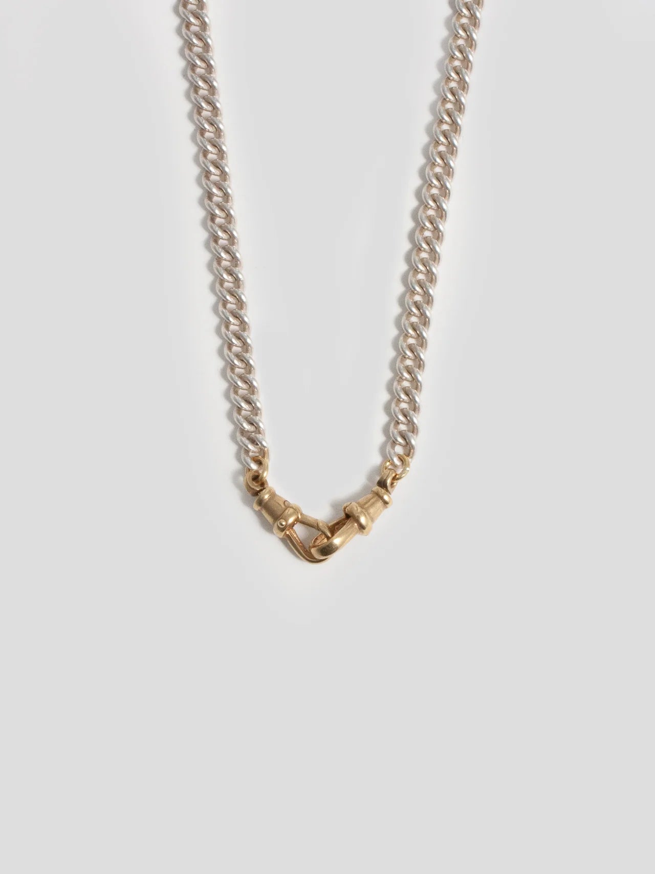 Flat lay of the Vintage Clip Chain in Silver displayed on a textured surface emphasizing its unique curb chain structure.