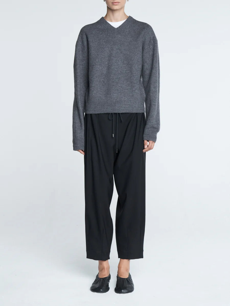 Barrel Leg Drawstring Pant in Black with focus on the ankle taper and pleat front detail.