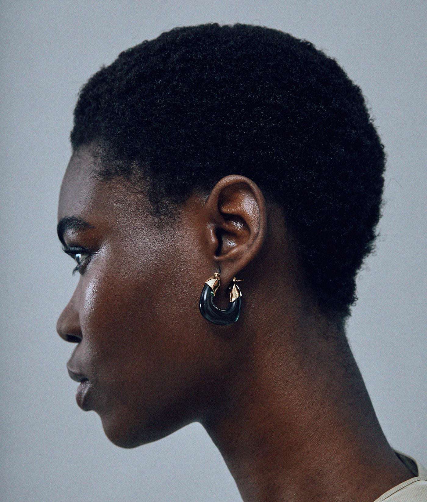 Close-up of Mini Organic Hoops in Forest showcasing the elegant design and color combinations of gold-plated brass and forest green resin.