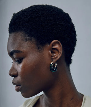 Lifestyle shot of the Mini Organic Hoops in Forest worn by a model, highlighting their versatility and chic appeal in everyday fashion.