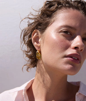 Close-up view of Mini Organic Hoops in Apple, showcasing the gold-plated brass and vibrant red resin design by Lizzie Fortunato.