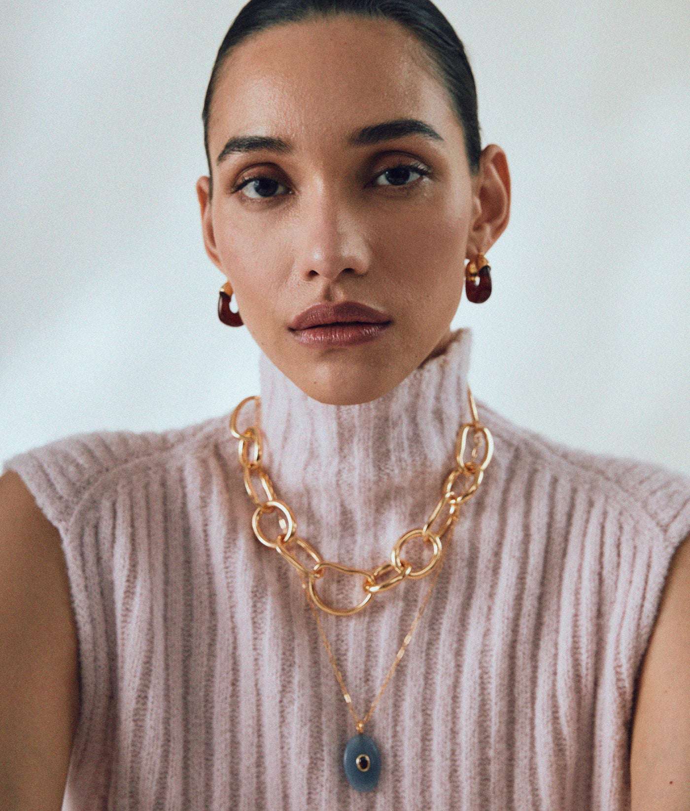 Mini Organic Hoops in Currant - Close-up view of gold-plated brass hoop earrings with a chic deep red resin finish.