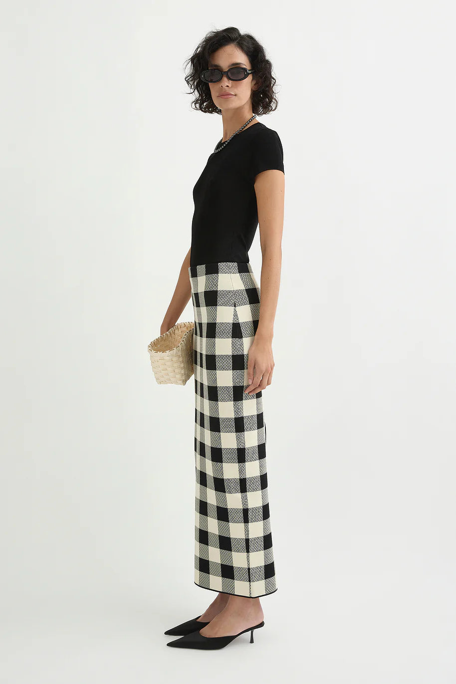 Model wearing the Pippa Skirt in Heritage Plaid styled with a simple black top, showcasing the versatile and chic look.