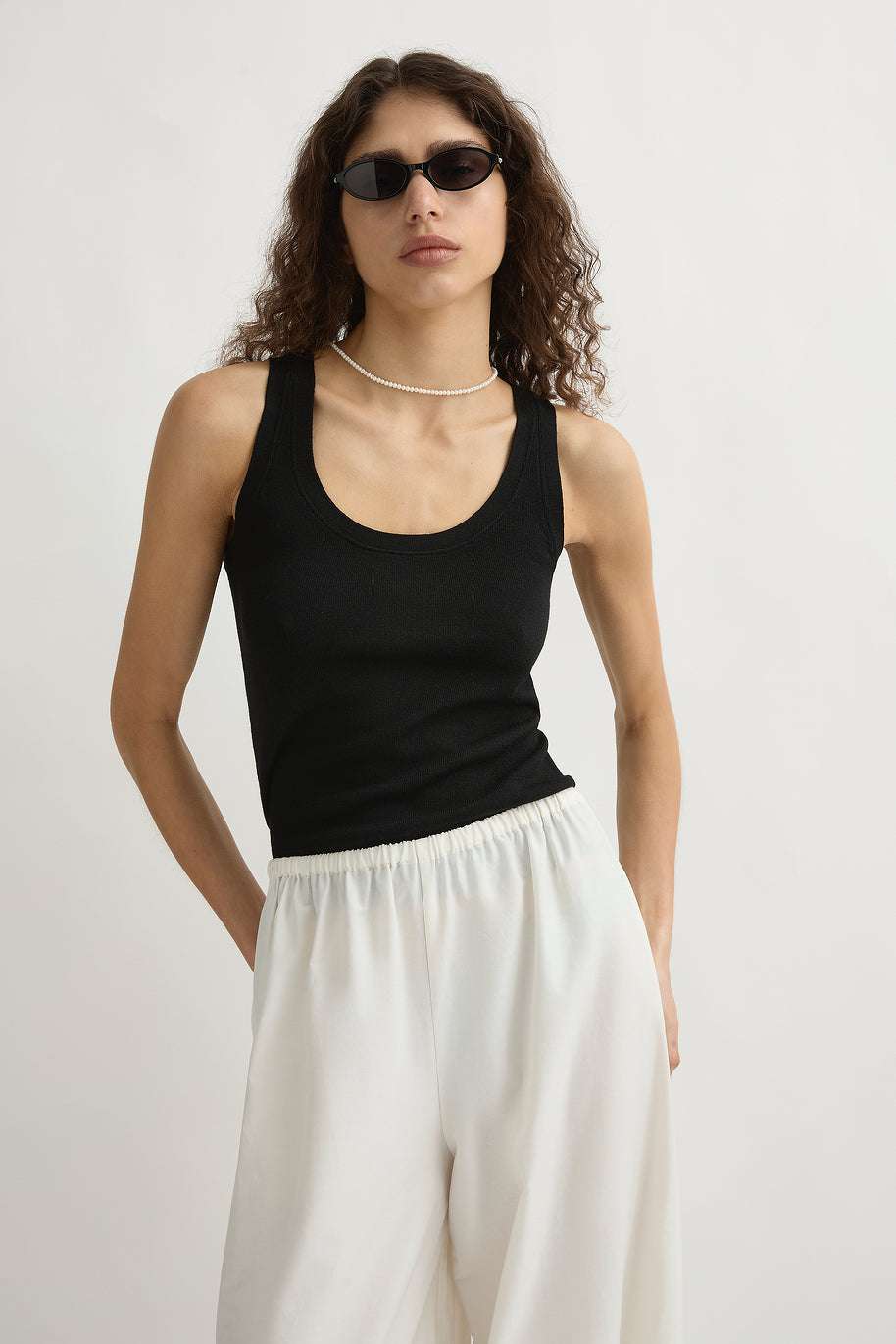 The elegant scooped neckline of the Finley Tank in Black displayed against a neutral background.