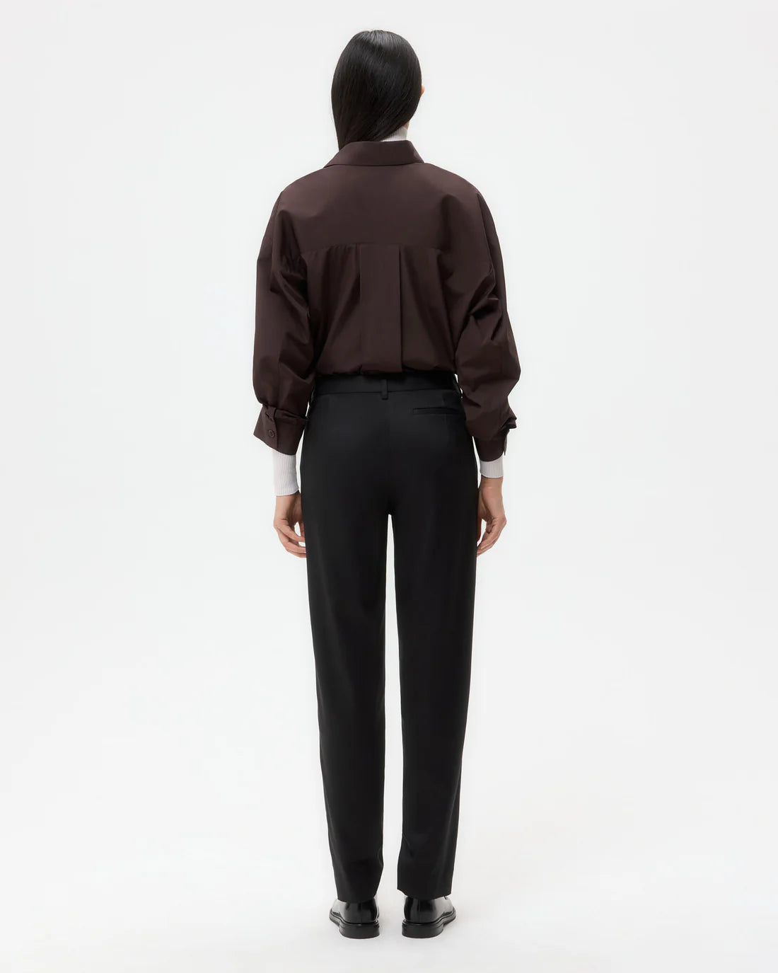 Harrison Pant in Black featuring front creases and side slip pockets, styled with a casual top.