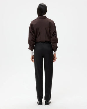 Harrison Pant in Black featuring front creases and side slip pockets, styled with a casual top.