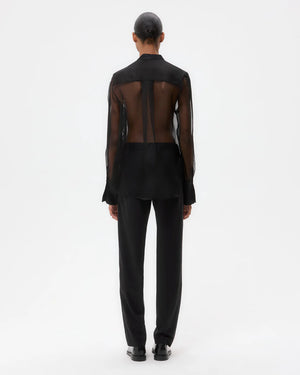 Model wearing the Peyton Top in Black, demonstrating the relaxed fit and shirttail hem in a stylish setting.