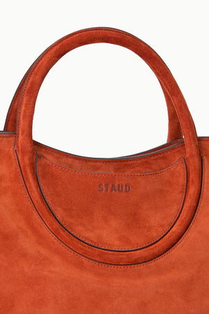 Versatile Maude Satchel in Auburn Suede worn on the shoulder.