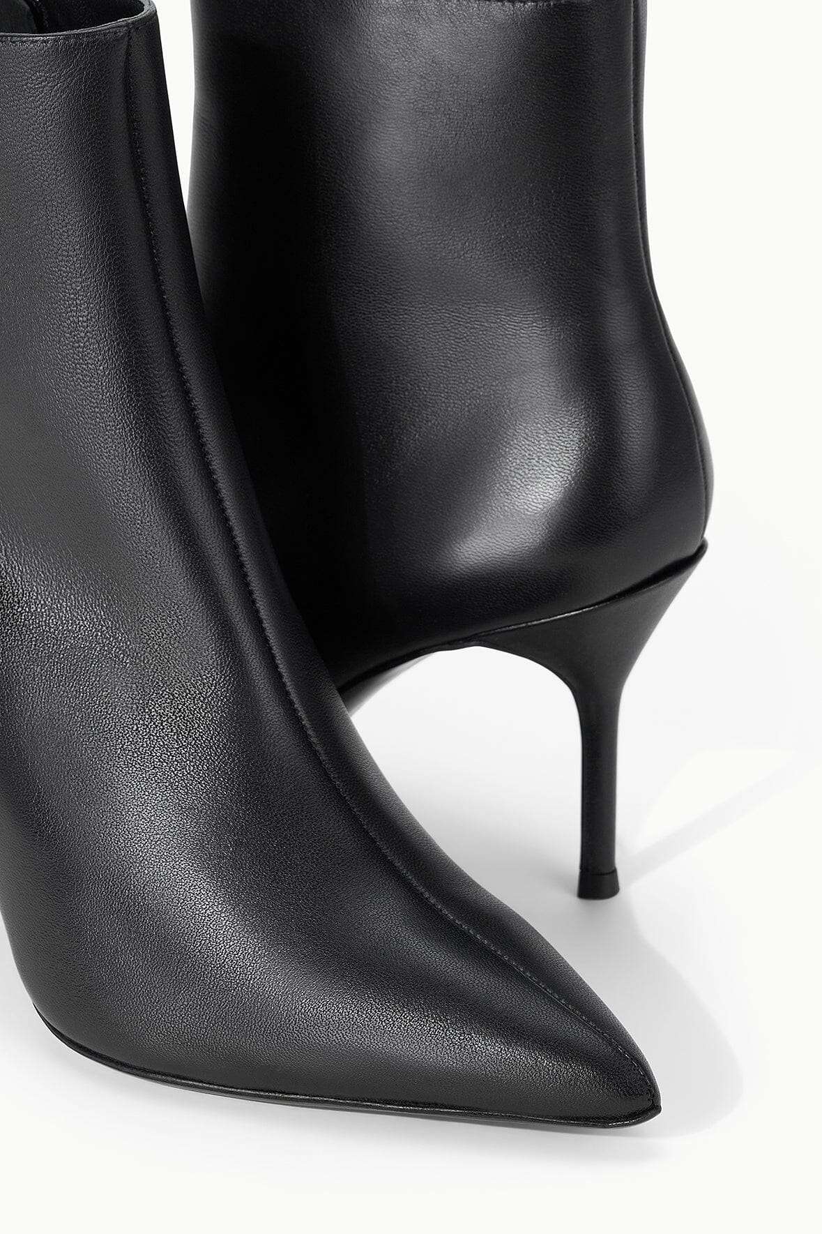 Staud Sebastian Ankle Boot in Black on a stylish backdrop, emphasizing its trendy look.