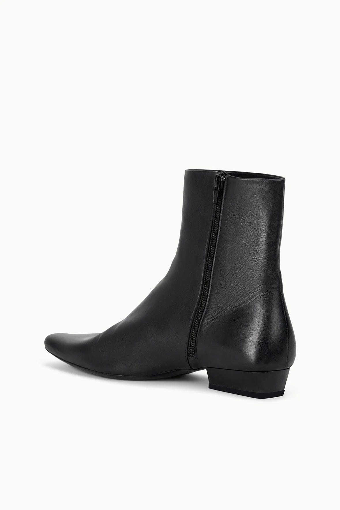 Wally Flat Ankle Boot in Black by Staud displayed in a stylish setting, emphasizing its versatility for outfits.