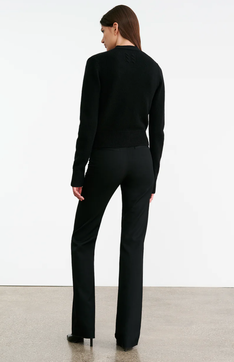 Back view of the Charmaine Cashmere Cardigan in Black, showing off the unique center back cable knit design.