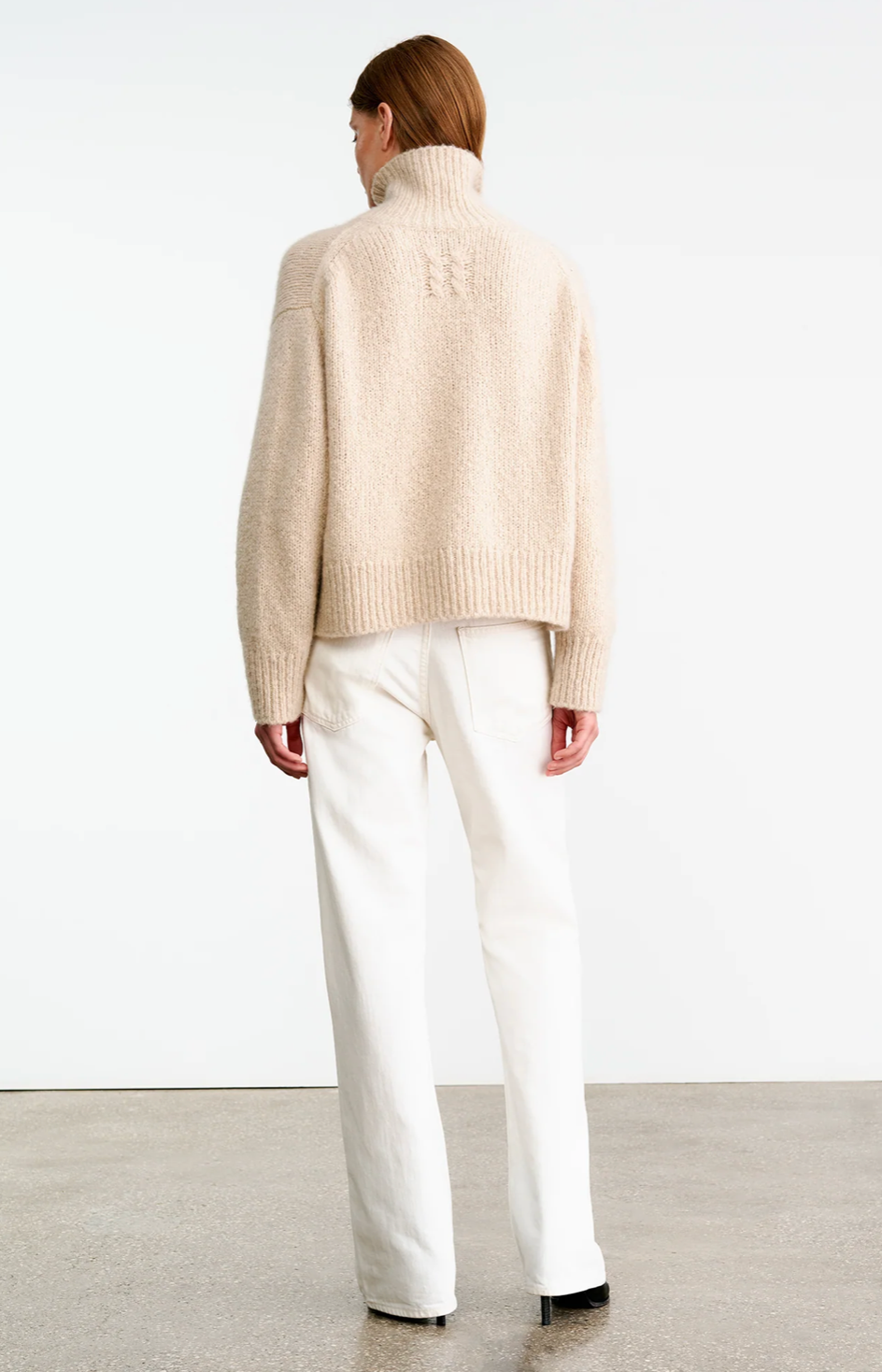 Detailed view of the Tabitha Sweater in Beige Melange with signature center back cable knit.