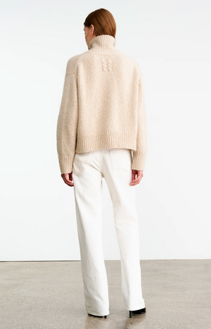 Detailed view of the Tabitha Sweater in Beige Melange with signature center back cable knit.