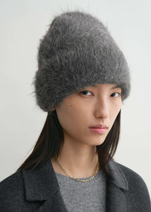 Alpaca Beanie Hat in Dark Grey Melange worn by a model, demonstrating its fashionable fold-over style and versatility from TOTEME.