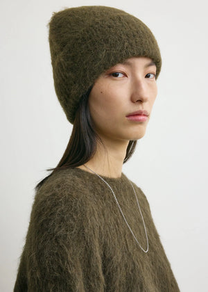Model wearing the Alpaca Knit Beanie in Pepper by TOTEME, demonstrating its versatile styling options.