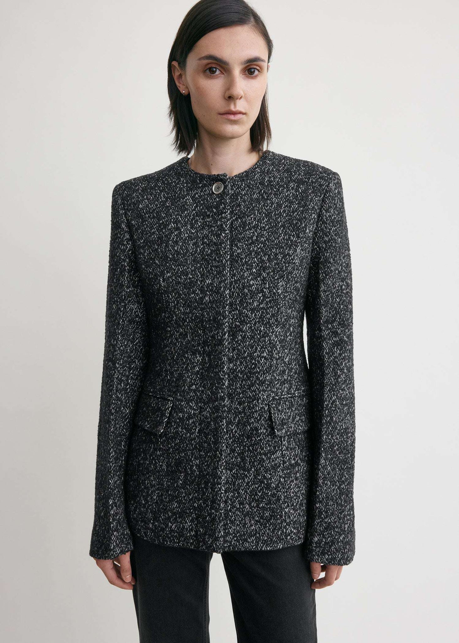 Detail shot of the silver-tone buttons on the Collarless Cinched Jacket in Black/White adding a touch of elegance.