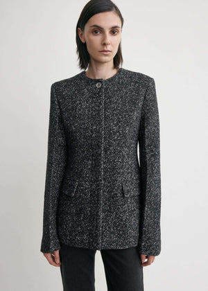 Detail shot of the silver-tone buttons on the Collarless Cinched Jacket in Black/White adding a touch of elegance.