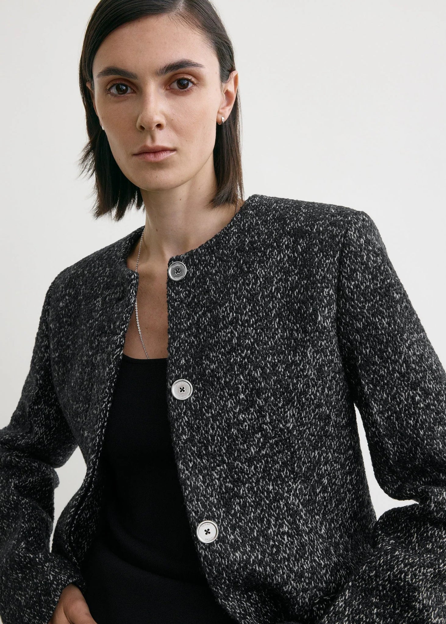 Flat lay of the Collarless Cinched Jacket in Black/White against a soft background, emphasizing its chic design.