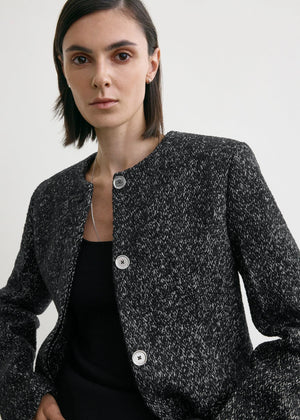 Flat lay of the Collarless Cinched Jacket in Black/White against a soft background, emphasizing its chic design.
