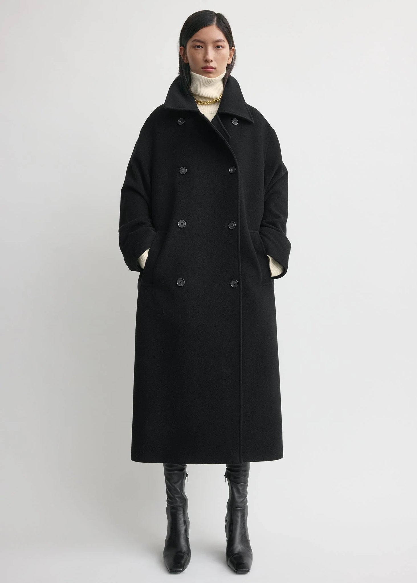 Side view of the Shield Coat in Black by TOTEME, showcasing its clean collar and cozy wool blend.