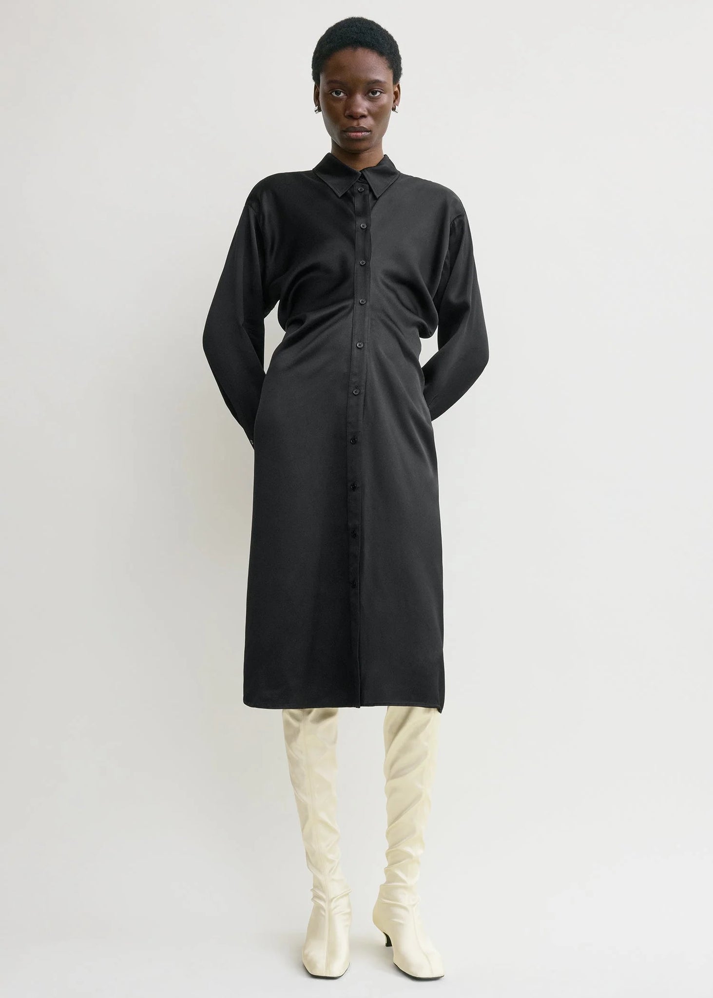 Close-up of the buttoned placket and collar of the Slouch Shirtdress in Black by TOTEME showcasing quality craftsmanship.