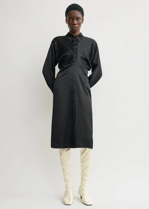 Close-up of the buttoned placket and collar of the Slouch Shirtdress in Black by TOTEME showcasing quality craftsmanship.