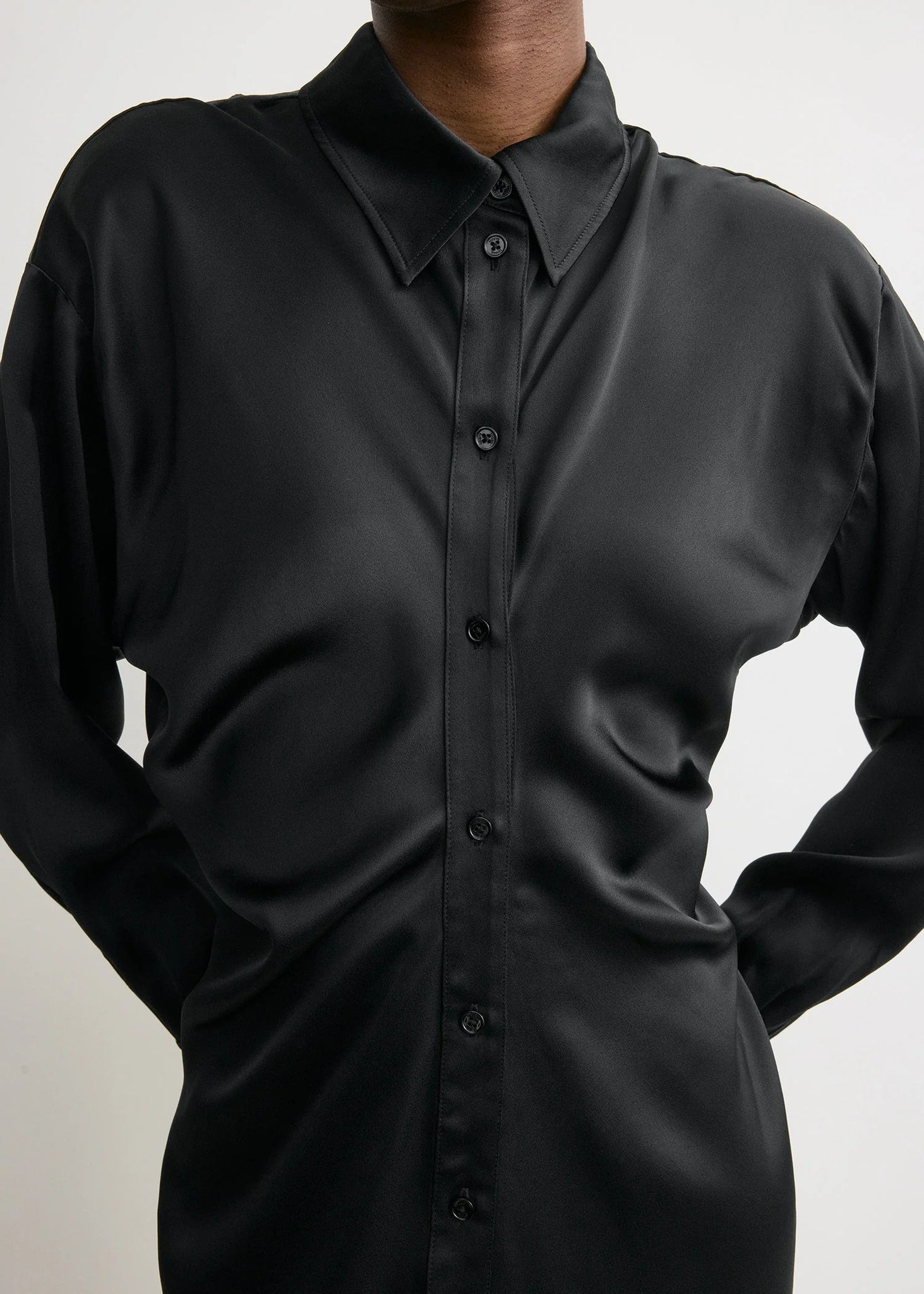 Detail of the fabric texture of the Slouch Shirtdress in Black by TOTEME highlighting its luxurious 100% viscose composition.