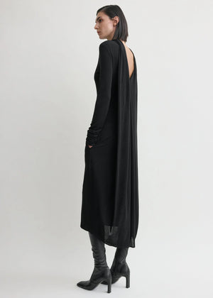 Side view of the Cocoon Cape Dress in Black by TOTEME, emphasizing the long sleeves and exquisite back design.