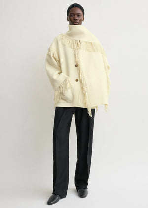 Close-up of the Fringed Scarf Jacket in Winter White, highlighting the unique fringe details and luxurious feel.
