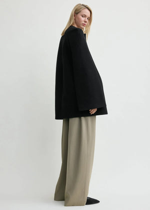 Model wearing the Bell-Sleeve Jacket in Black by TOTEME paired with tailored pants, perfect for work.