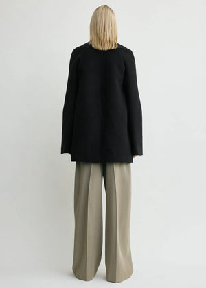 Stylish Bell-Sleeve Jacket in Black by TOTEME displayed on a hanger, featuring a collarless neckline.