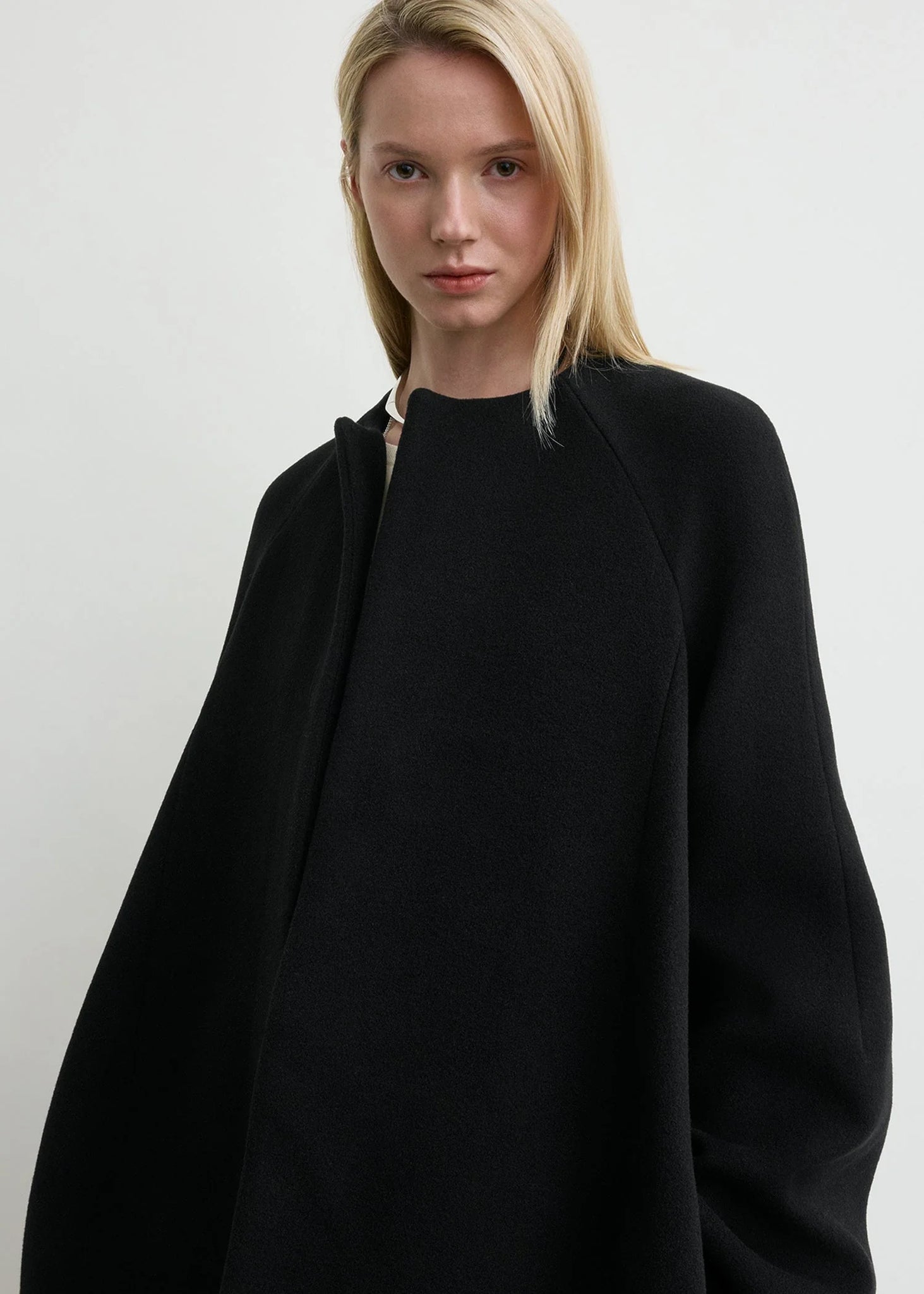 The Bell-Sleeve Jacket in Black by TOTEME, capturing its oversized silhouette and elegant design.