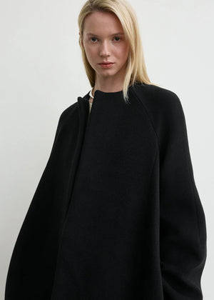 The Bell-Sleeve Jacket in Black by TOTEME, capturing its oversized silhouette and elegant design.