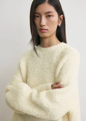 Back view of the Boxy Boucle Knit in Milk showing the dramatic boxy silhouette and extra-long sleeves.
