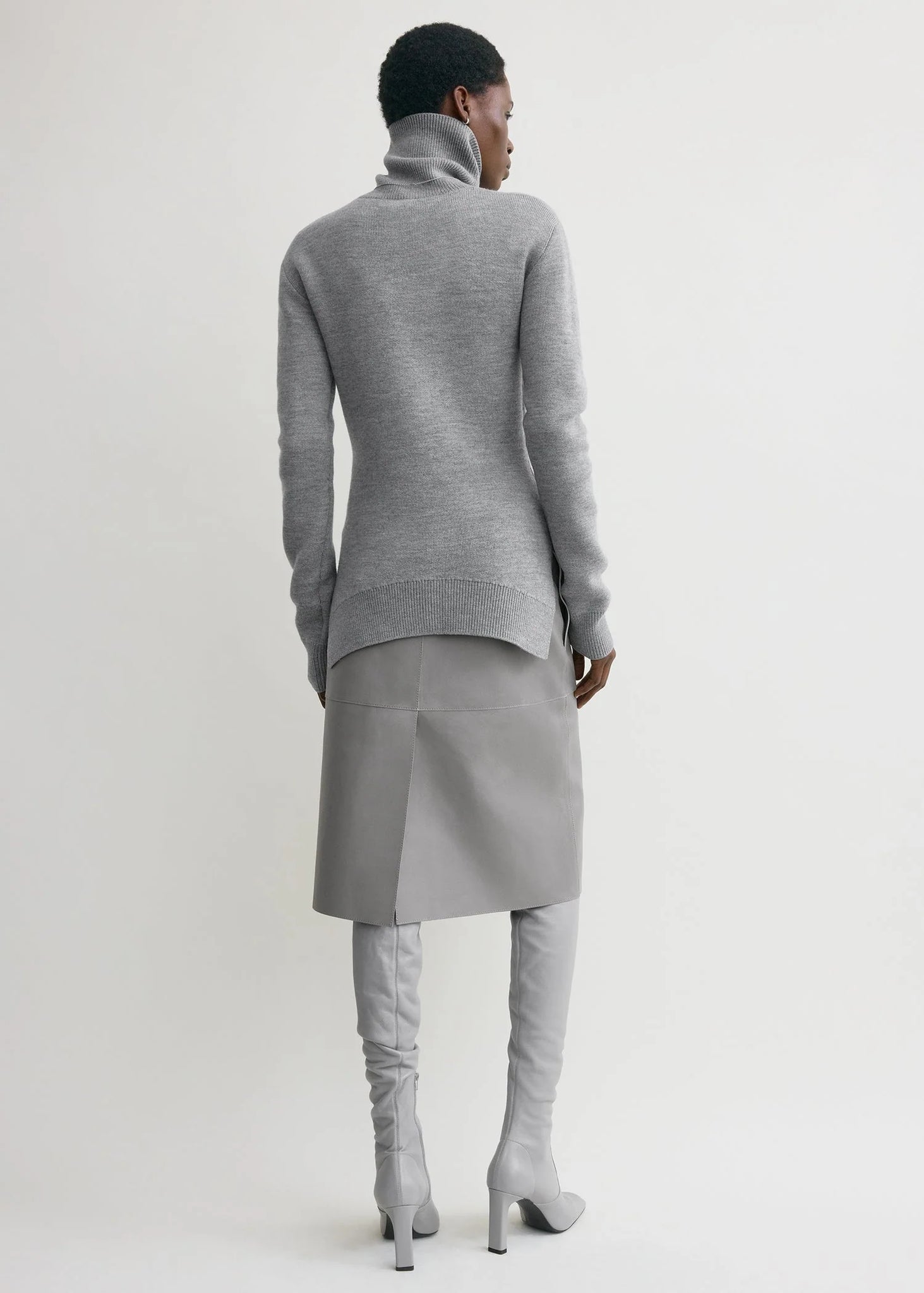 Model wearing the High-neck Double Knit Sweater in Pale Grey Melange paired with an A-line skirt.