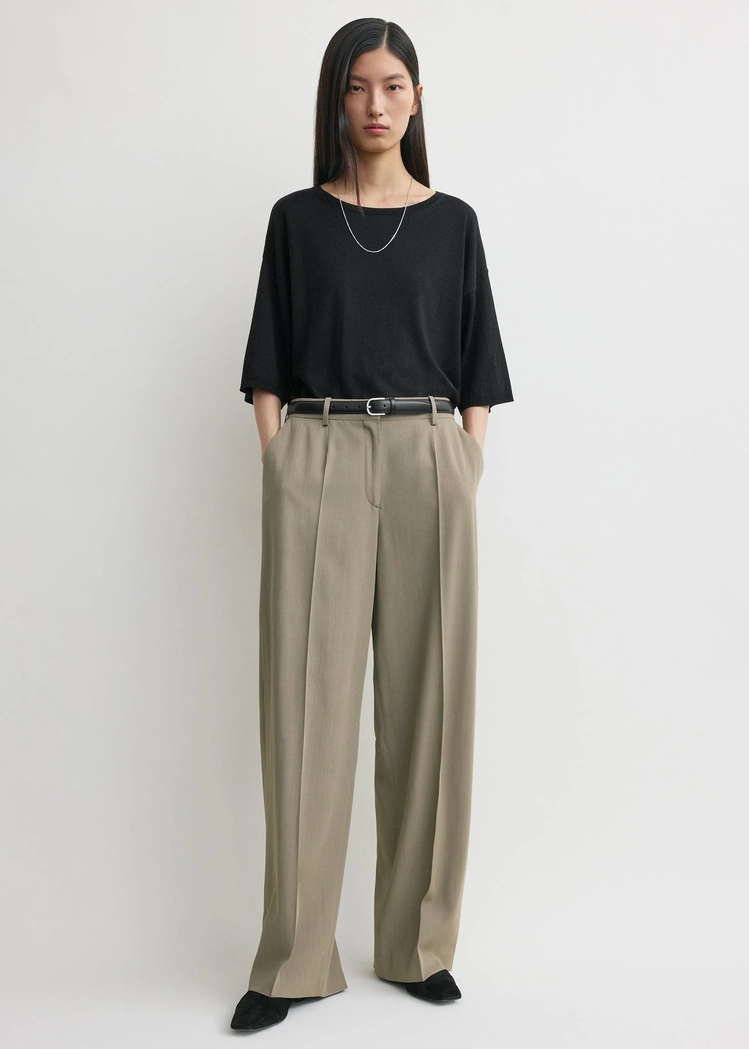 Close-up view of the fabric texture of the Wide Fluid Trousers in Taupe by TOTEME.