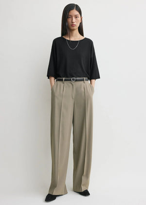 Close-up view of the fabric texture of the Wide Fluid Trousers in Taupe by TOTEME.