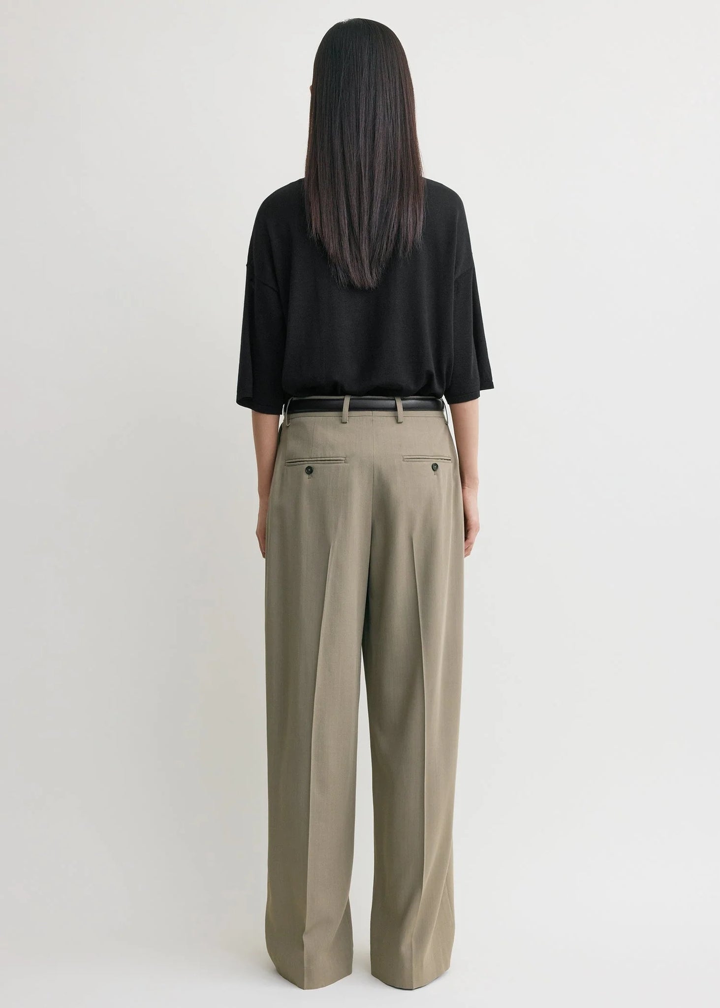 Side profile of the Wide Fluid Trousers in Taupe demonstrating the generous leg drape by TOTEME.