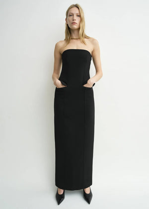 Stylish view of the TOTEME Strapless Pocket Dress in Black highlighting the back zipper and slit detail.